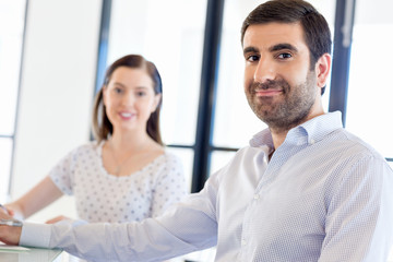 Image of two young business people in office