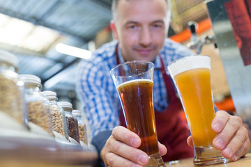 brewer in uniform tasting beer at the brewery
