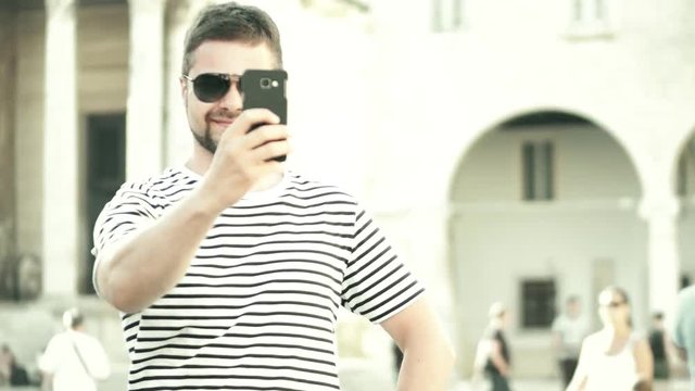 Young bearded man making selfies with his phone on vacation