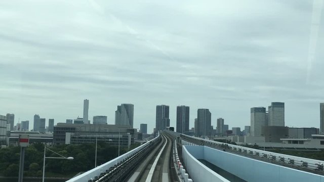  The train of the automated monorail guideway transit system (AGT) called the Yurikamome enter into the station in Tokyo 4K