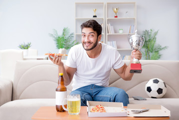 Man eating pizza having a takeaway at home relaxing resting