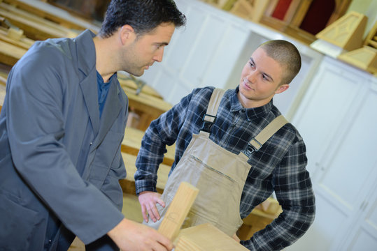 carpenter and apprentice fitting a kitchen