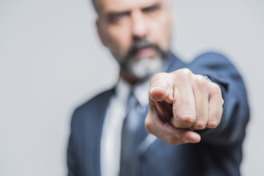 Angry senior man pointing his finger towards you, accusing and blaming