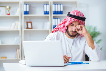 Arab businessman working in the office doing paperwork with a pi