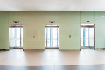 Open and closed chrome metal office building elevator doors.