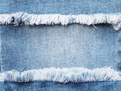 Edge frame of blue denim ripped over jeans texture background.