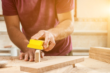 man sanding a wooden