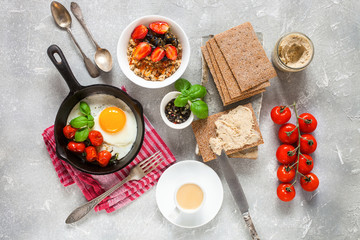 Breakfast - fried eggs from a tomato, muesli with berries