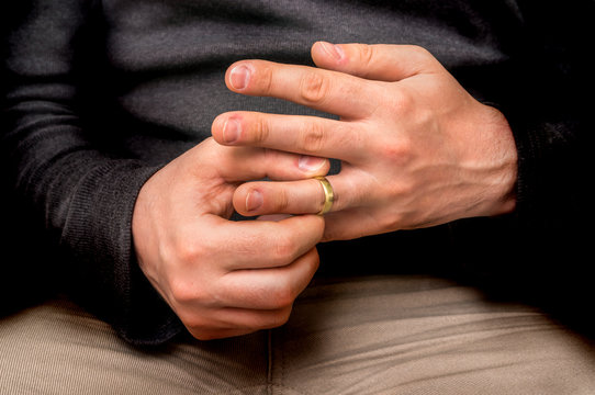 Man is taking off his wedding ring - divorce concept