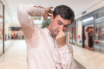 Man with sweating under armpit in shopping center