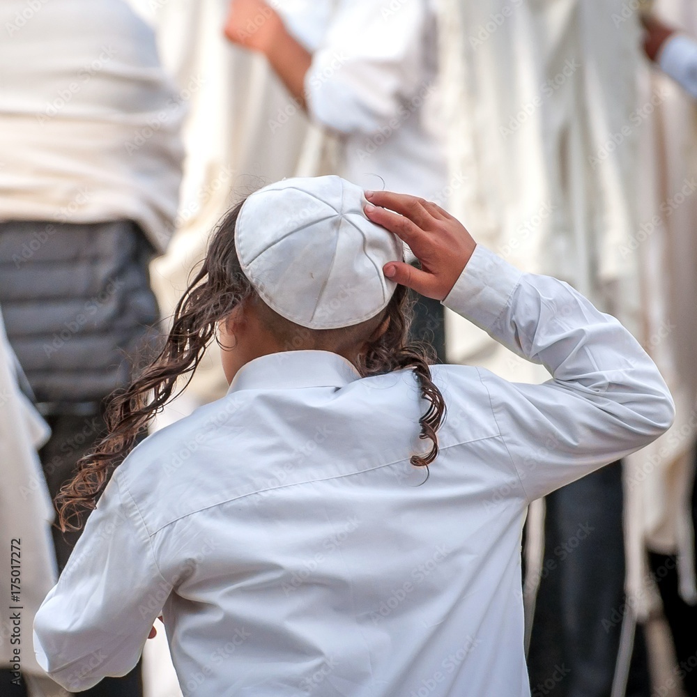 Wall mural A young Jewish Hasid boy in a traditional headdress of a kippah and with long payos.