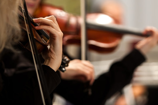 Hands of a woman playing the violin in an orchestra