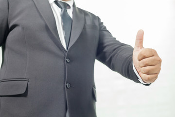 businessman in a suit opening palm hands and Thumbs Up