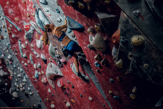 Professional female climber on a bouldering wall.