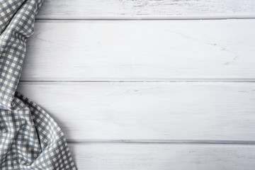 The Crumpled checkered tablecloth or napkin on empty white wooden table with copy space for food cooking  menu background concept , top view or overhead shot