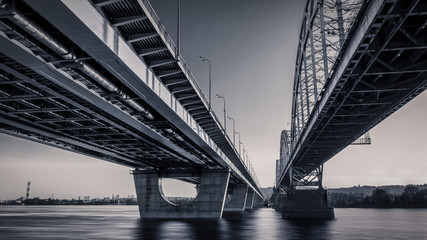 Fototapeta premium Sunset skyline and landscape of bridge over river. Evening city