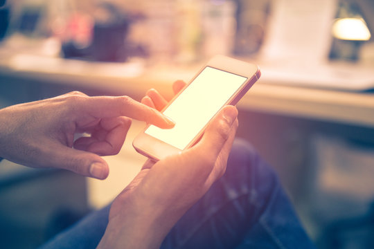 Close Up Of Generic Design Smart Phone Holding In Male Hands For Texting Message. Document On The Table,  Filter Effect.