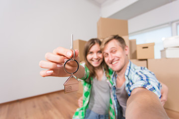 Happy funny couple showing keys of new home