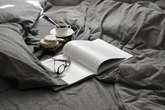 Breakfast and book in grey bed at sunlight