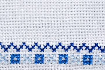 Embroidered fragment on white flax. Cross stitch.