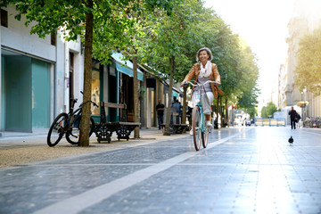 Senior woman riding city bike in town