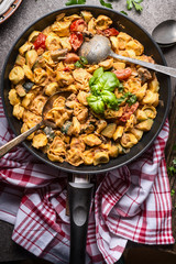 Vegetarian tortellini pot with vegetables sauce and spoons , top view, close up. Healthy cooking and eating. Italian food concept