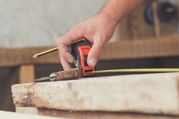 Carpenter working on raw wood / boards / plank.