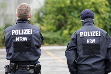 Zwei Polizisten NRW von hinten, Hundertschaft, Uniform