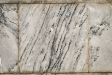 The texture of the brushed stone, marble. Different shades of gray with splotches, stripes, lines. Close-up