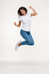 Full length portrait of a pretty joyful woman jumping