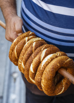Man holding a stick with Simit bread, Balat, Istanbul, Turkey.