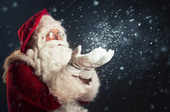 Santa Claus blowing magic snow of his hands