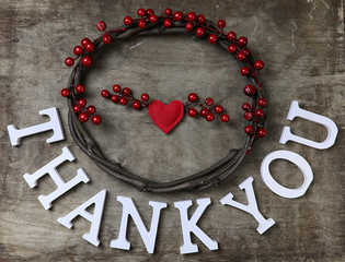 red santa hat on textured wooden background and Thank you wooden white letters