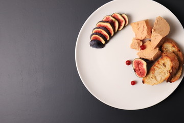 foie gras with croutons, figs and redcurrant. in a white plate, on a marble table © oleh91