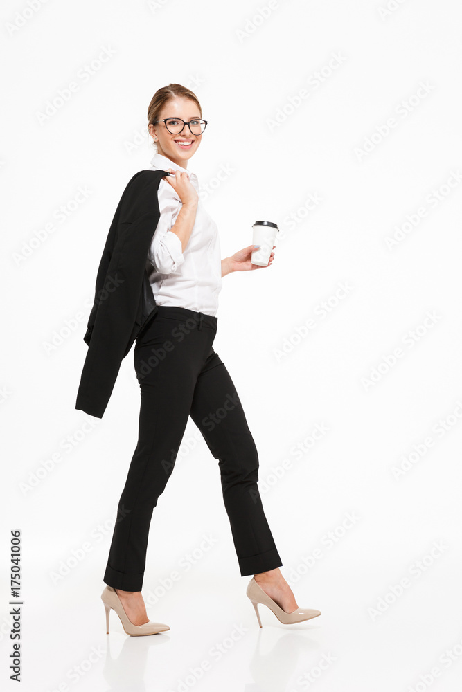 Wall mural Full length side view image of smiling blonde business woman