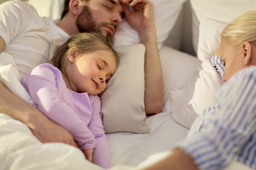 Obraz na płótnie Canvas happy family sleeping in bed at home