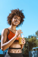 fit african-american woman drinking juice