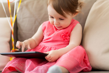 baby girl with tablet pc at home