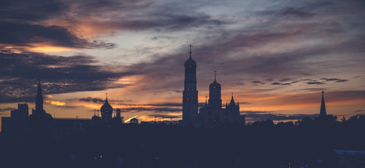 Naklejka premium Dark silhouette of buildings against the background of a bright sunset sky, Moscow, Russia, beautiful urban background