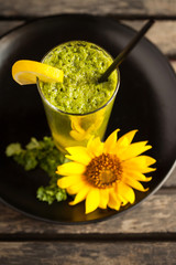 Green smoothie on the plate at wooden table - High angle view