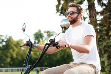 Side view of cheerful berded man in sunglasses