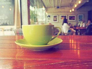 Coffee cup on wooden table .
