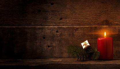 Erster Advent mit Textraum, Kerze mit Tannenzweig vor Holzhintergrund