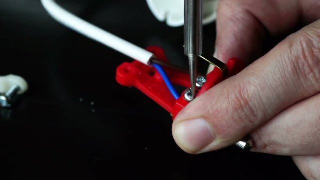 Close up.  Repair of electrical plug, tightening screw with a screwdriver.
