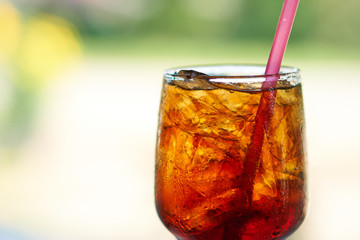 A glass of cola served with ice cubes