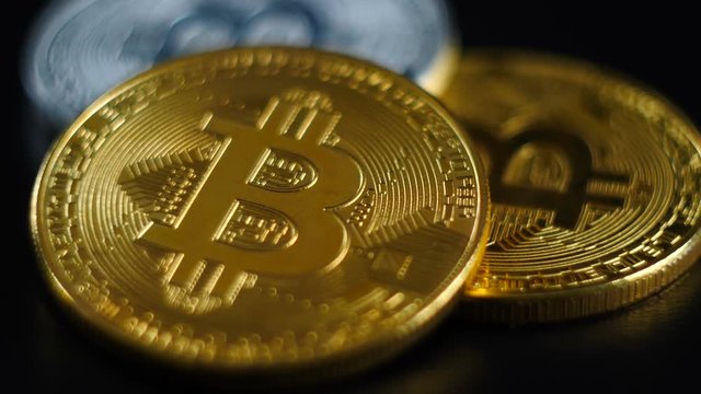 Gold and silver bitcoins lie on a black background.