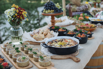 Outdoors fourchette table with traditional moldavian appetizers and fresh flowers - 175055660