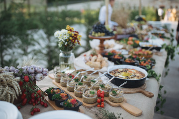 Outdoors fourchette table with traditional moldavian appetizers and fresh flowers - 175055672