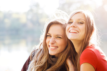 two young females laughing looking at camera closeup having good time