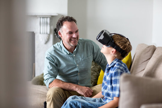 Boy using a VR headset game at home with Father